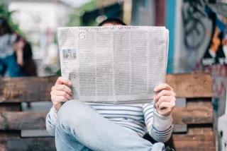 Eine Frau liest die Zeitung